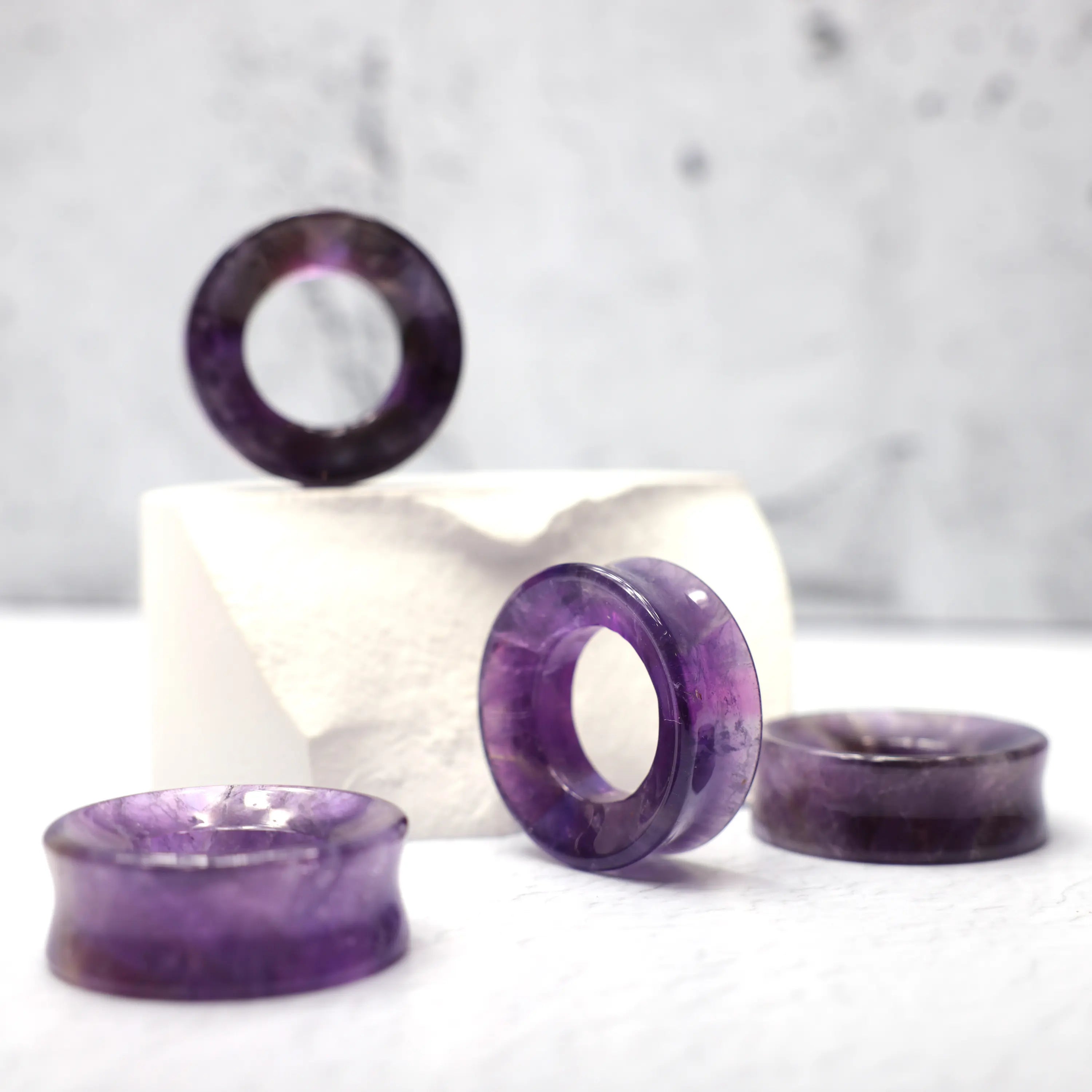 Purple Amethyst Tunnels - Close up photo showing the vibrance of amethyst against the light. Very detailed, interior crystal lines, arrange in a group on a white background. Sizing of tunnels are approx 35mm