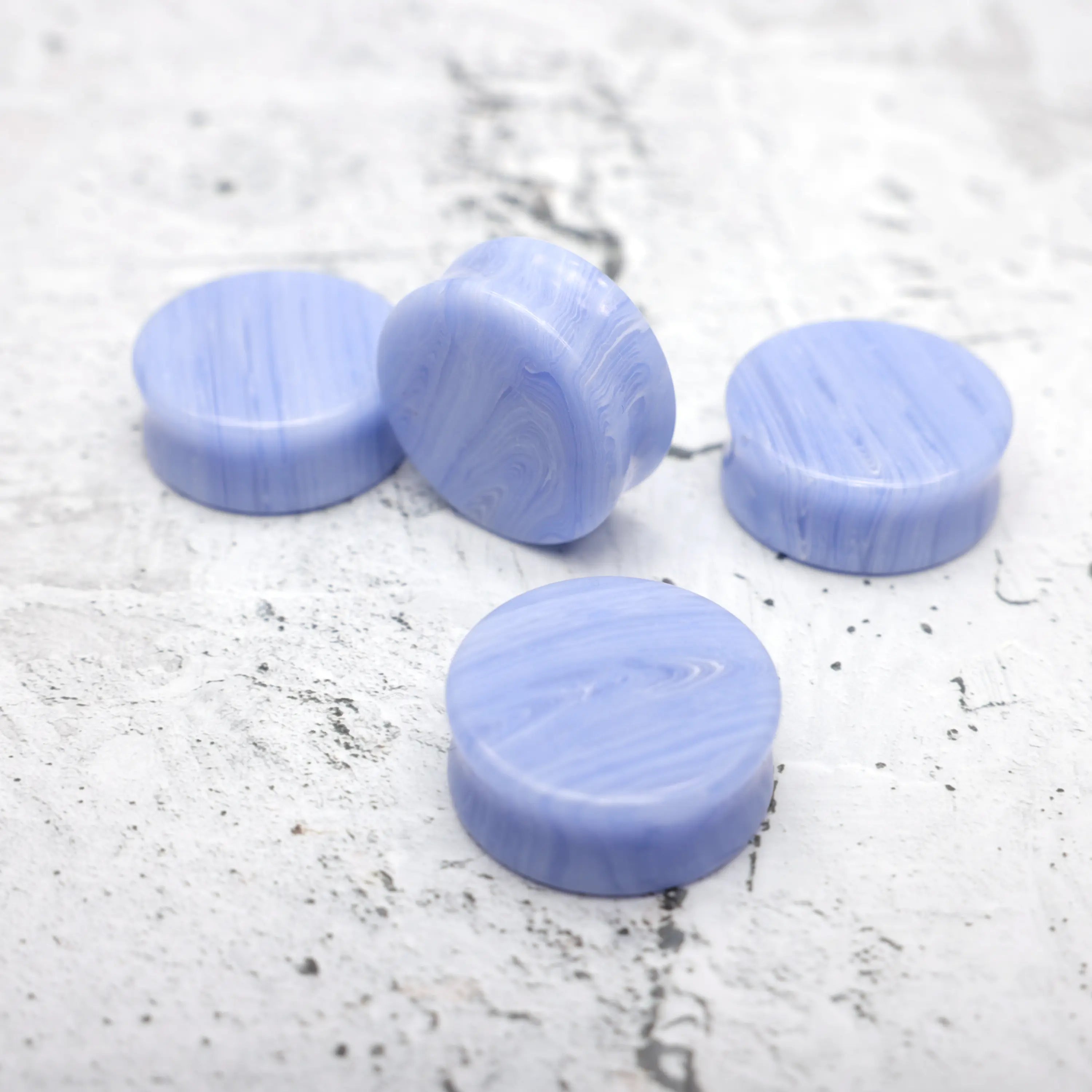 Blue Lace Agate Concave Plugs  - Main product photo showing a group of blue lace agate plugs close up revealing white bands through the blue. Very vibrant colour